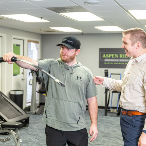 a physical therapist from Aspen Ridge Physical Therapy leads his patient through exercises to help his wrist and elbow pain